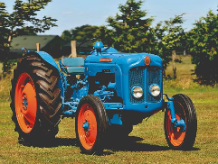 Een blauwe Fordson-tractor in een weide